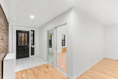 a view of a hallway with wooden floor and kitchen