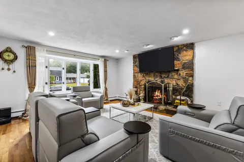 a living room with furniture a fireplace and a flat screen tv