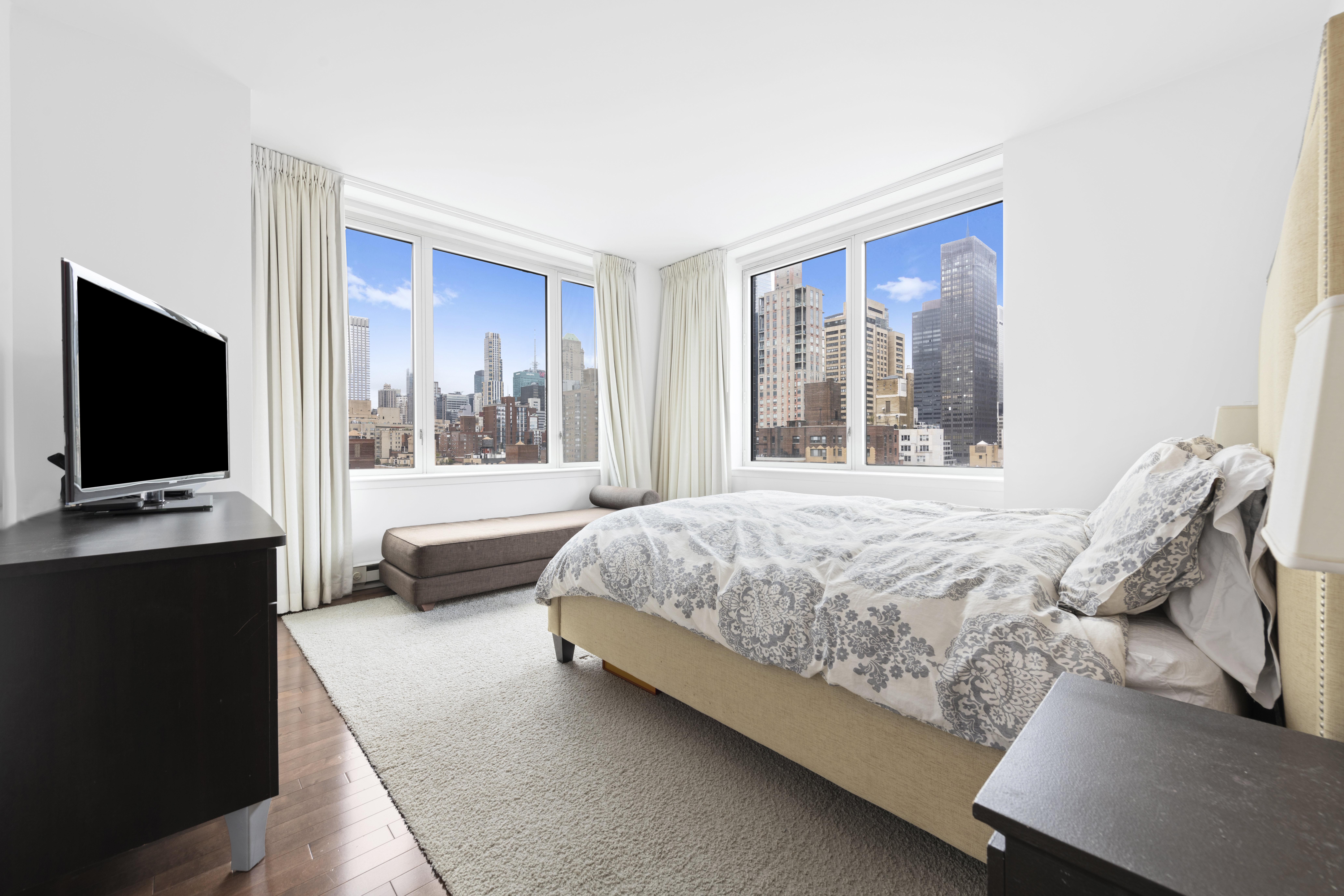 225 East 34th Street, Unit 19C Manhattan, NY 10016 - Photo 3 of 18 a bedroom with a bed and a flat screen tv