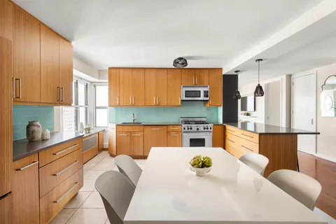 a kitchen with stainless steel appliances kitchen island granite countertop a table and chairs in it