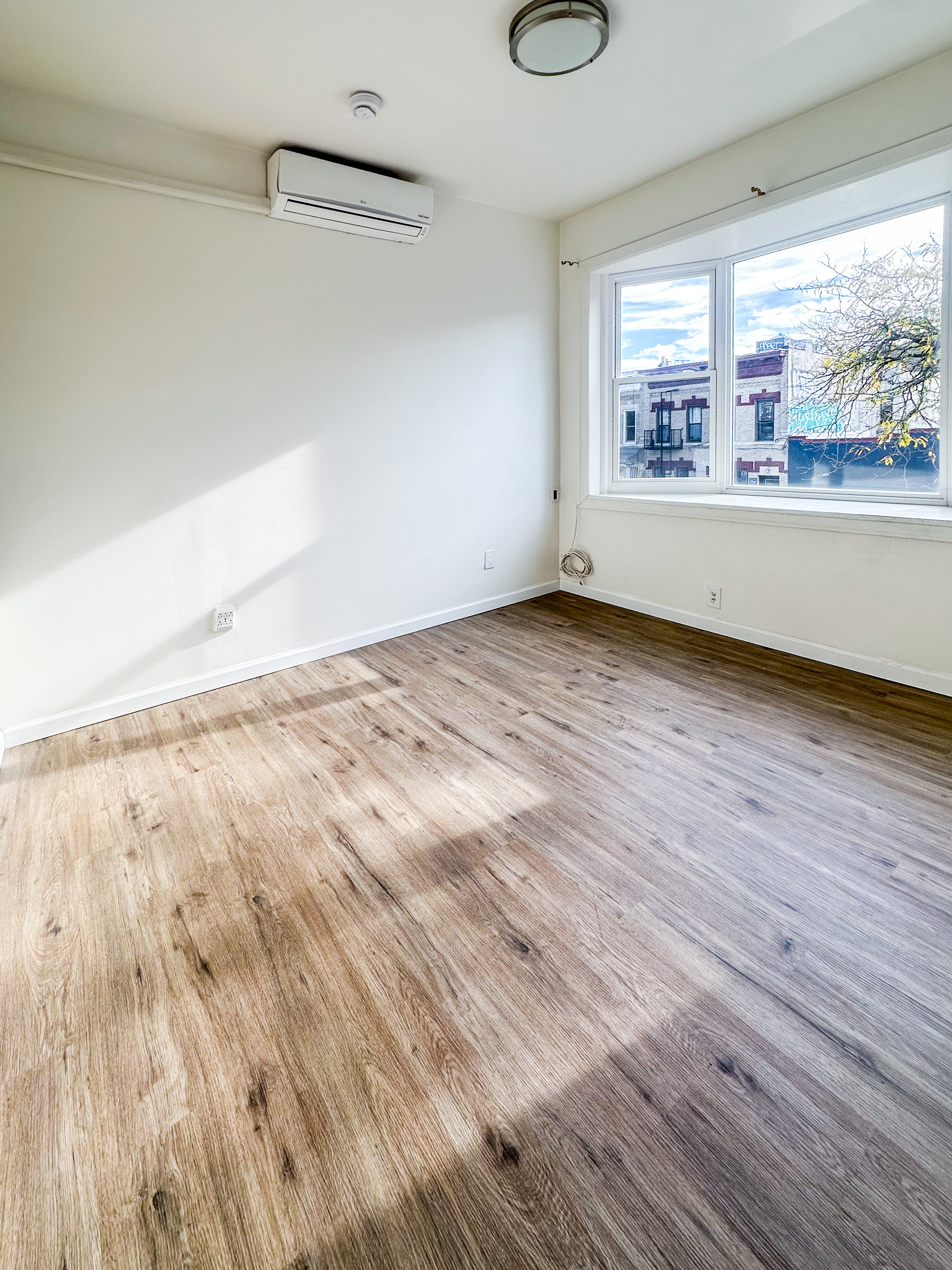 289 A Cooper Street, Unit 2 Brooklyn, NY 11237 - Photo 10 of 19 a view of a livingroom with wooden floor and window