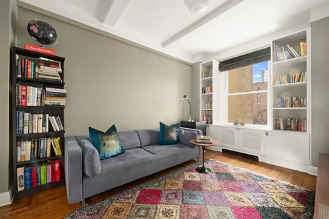 a living room with furniture and a book shelf