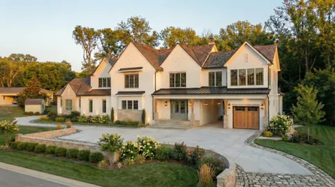 a front view of a house with a yard and trees