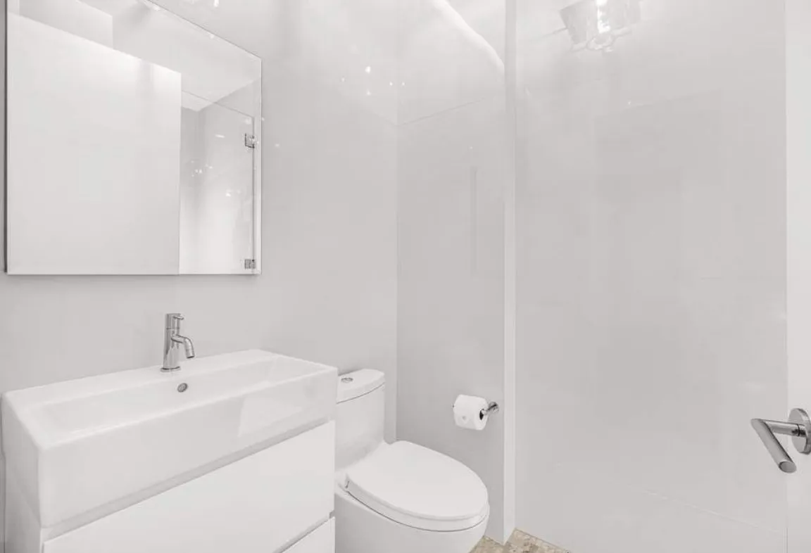 a white toilet sitting next to a bathroom sink