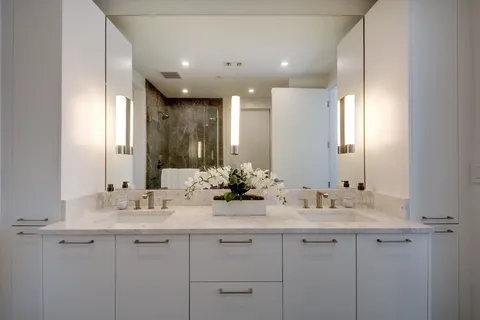 a bathroom with a double vanity sink mirror and shower