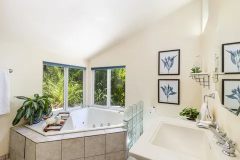 a bathroom with a tub a sink and a window