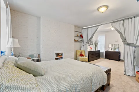 a bedroom with a bed a couch and a large window