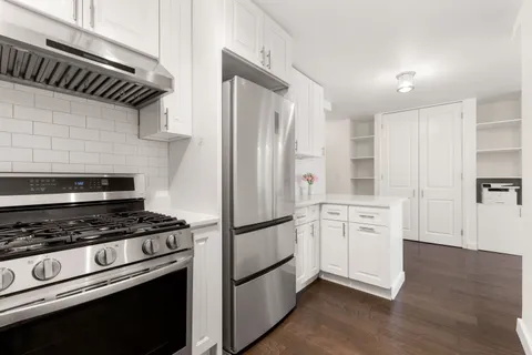 a kitchen with stainless steel appliances granite countertop a refrigerator and a stove top oven