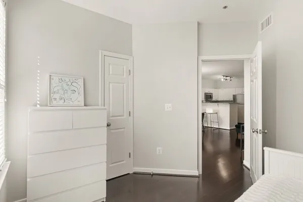 a view of a hallway with wooden floor and closet
