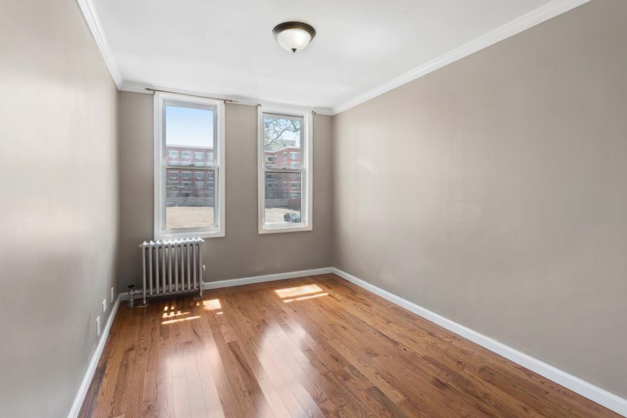 11-15 30th Drive, Unit 2F Queens, NY 11102 - Photo 4 of 6 an empty room with wooden floor and windows