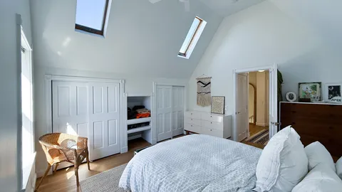 a bedroom with a bed and a refrigerator