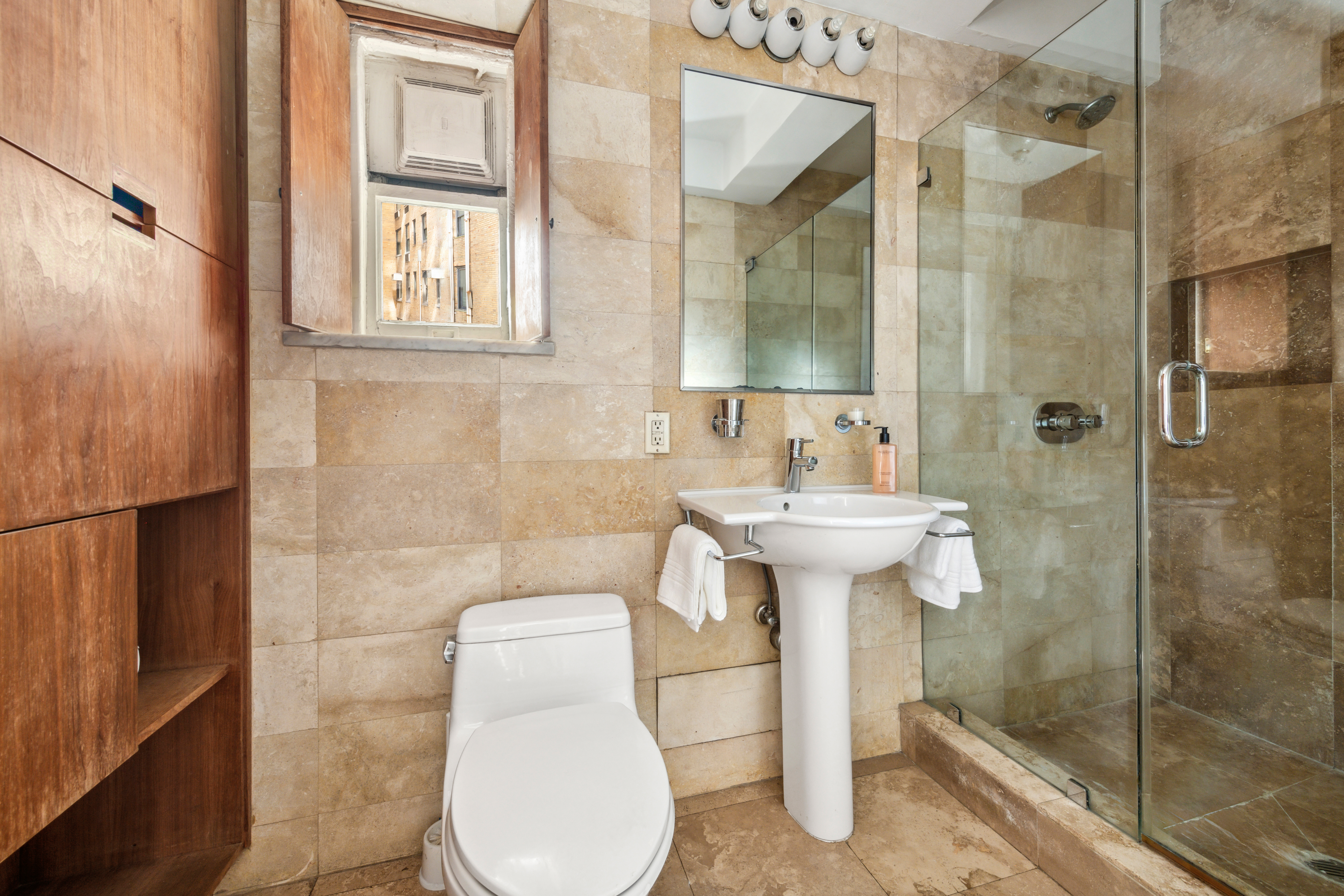 1 West 67th Street, Unit 501/502 Manhattan, NY 10023 - Photo 12 of 19 a bathroom with a sink a toilet and shower