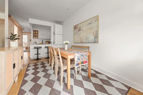 a living room with a black white checkered floor with a dining table and chair