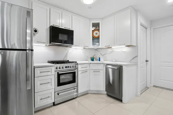 a kitchen with white cabinets and stainless steel appliances