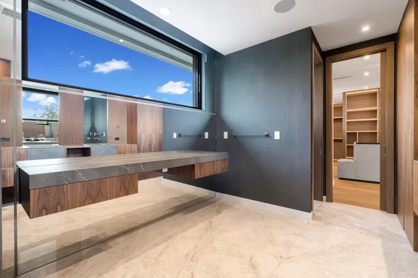 a large white kitchen with a large window and refrigerator