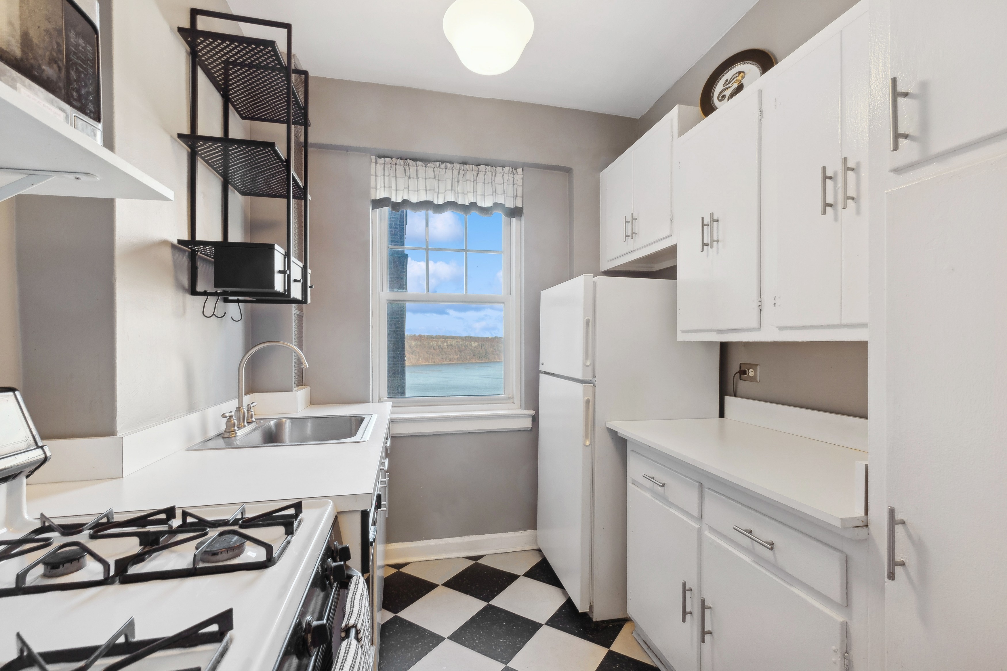 120 Cabrini Boulevard, Unit 107 Manhattan, NY 10033 - Photo 9 of 26 a kitchen with white cabinets and appliances
