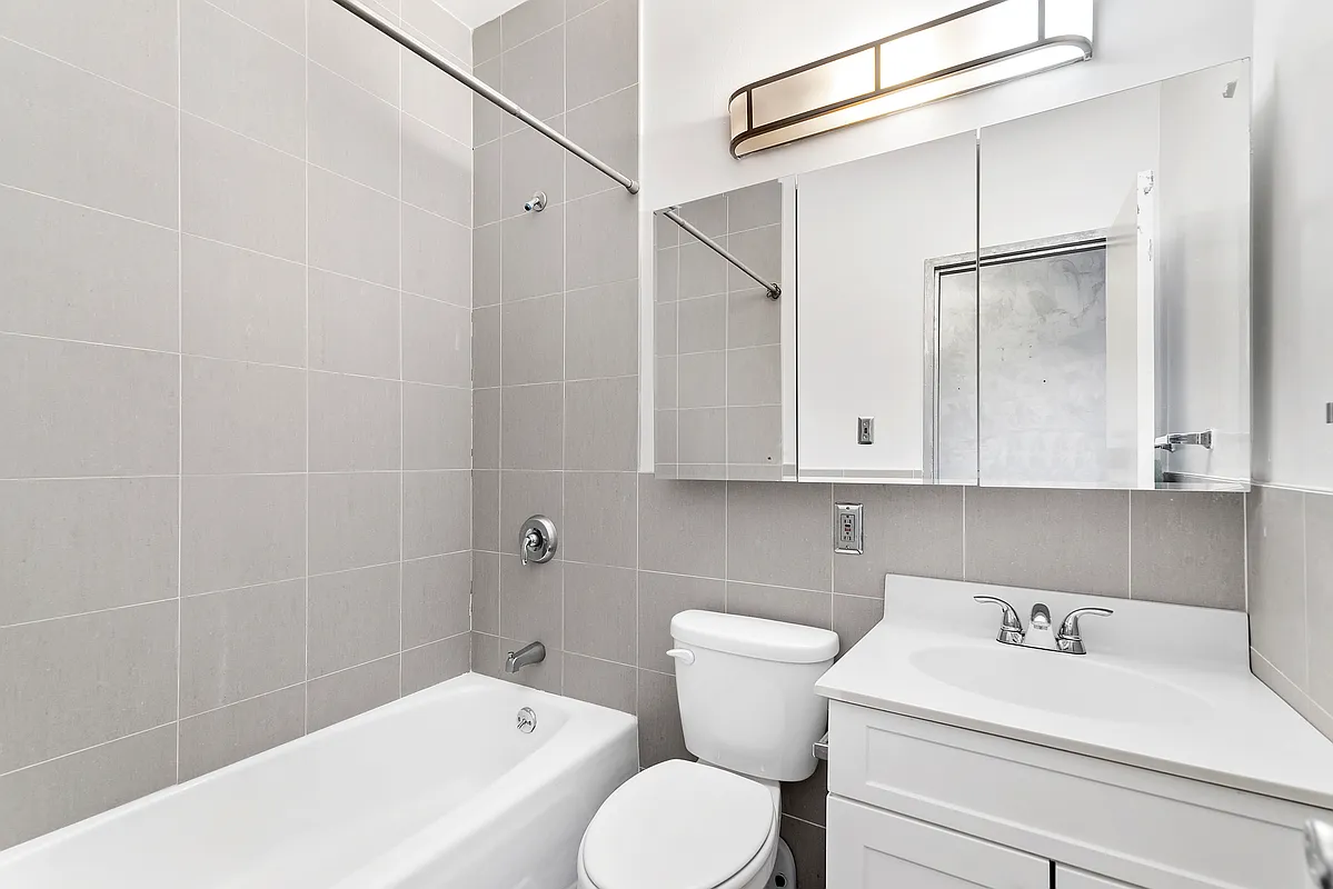 221 East 82nd Street, Unit 6A Manhattan, NY 10028 - Photo 7 of 11 a bathroom with a sink a toilet and shower