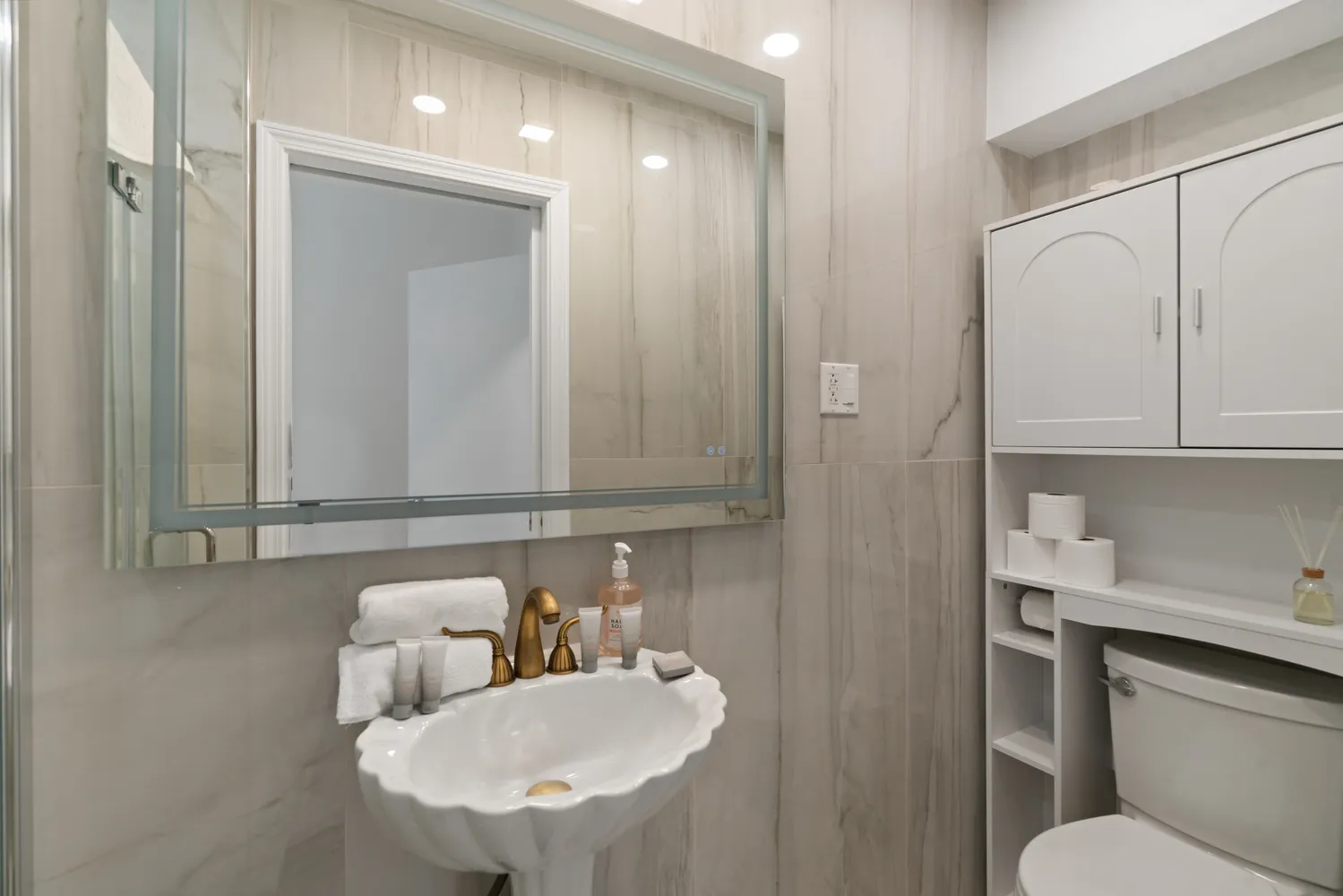 a bathroom with a sink toilet and mirror