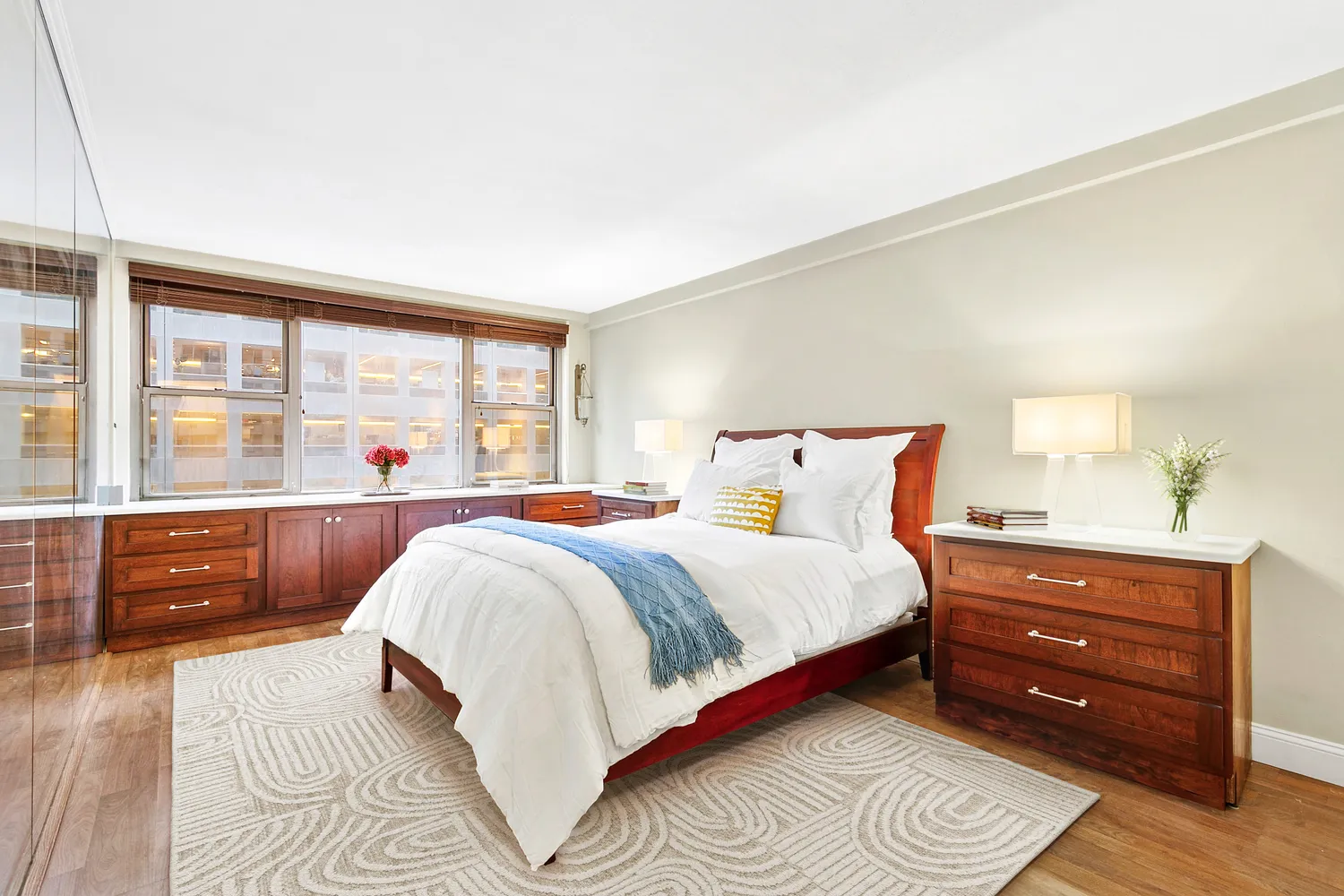 a bedroom with a bed and a dresser next to a window
