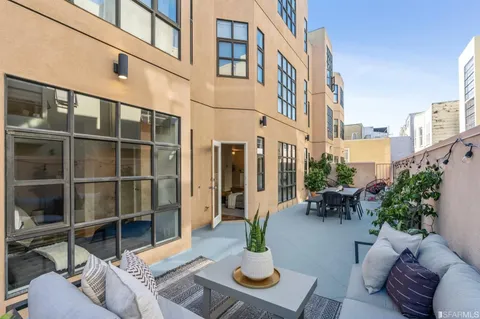 a view of a patio with couches table and chairs and potted plants