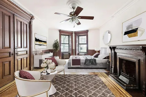 a living room with furniture a fireplace and a chandelier