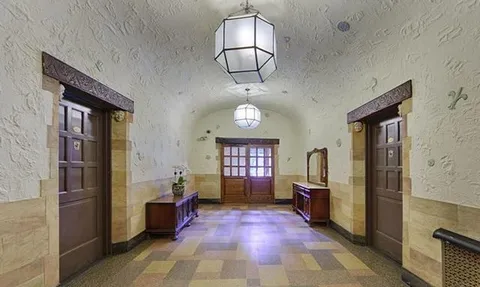 a view of a hallway with wooden floor windows and a kitchen