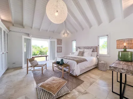 a spacious bedroom with a bed a table and chair