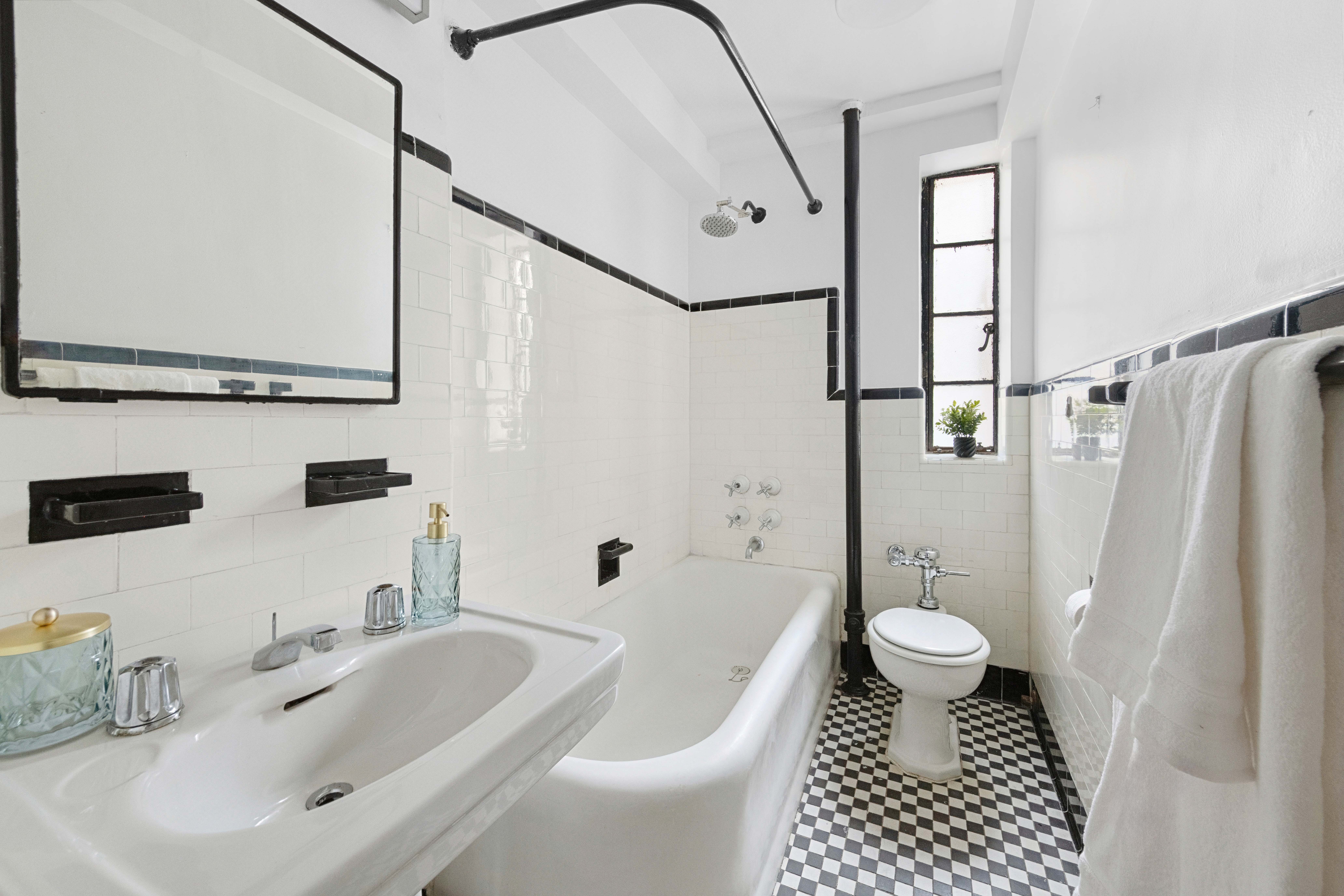 140 East 40th Street, Unit 7J Manhattan, NY 10016 - Photo 4 of 6 a bathroom with a sink toilet a mirror and shower