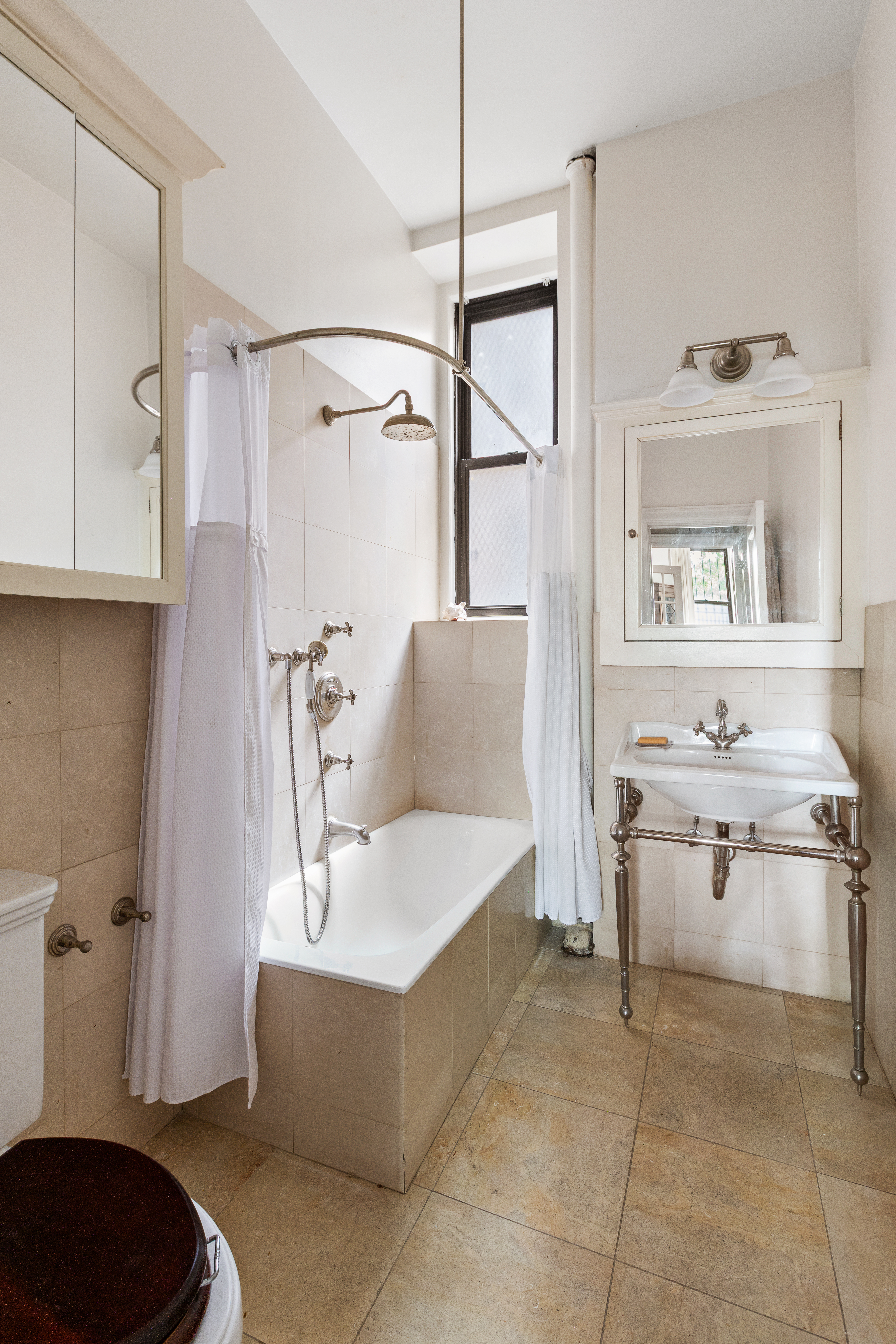 271 Central Park West, Unit 1D Manhattan, NY 10024 - Photo 9 of 12 a bathroom with a tub sink and mirror