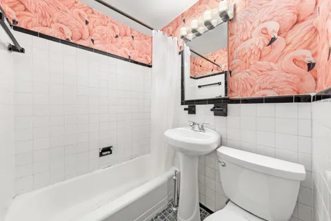 a bathroom with a sink and mirror with toilet