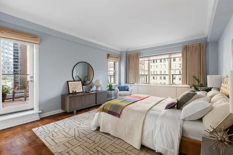 a bedroom with a bed and a dresser next to a window