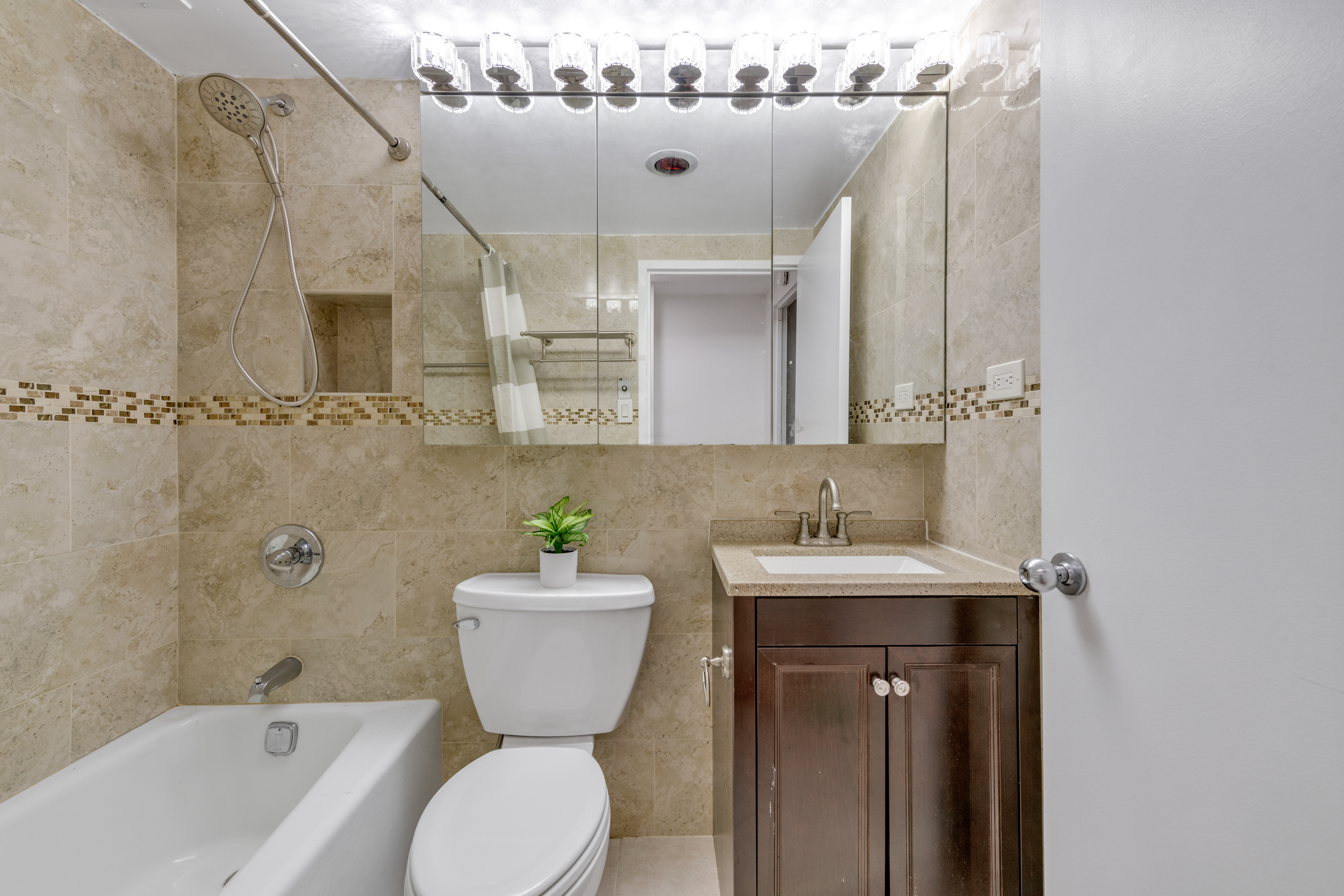150 West 51st Street, Unit 1528 Manhattan, NY 10019 - Photo 6 of 21 a bathroom with a sink and mirror with bathtub