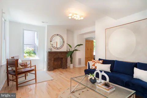 a living room with furniture a fireplace and a chandelier