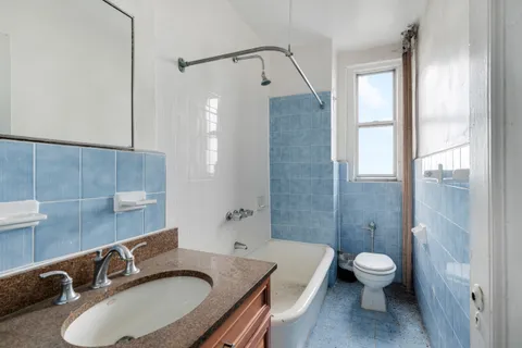 a bathroom with a granite countertop sink toilet a mirror and shower