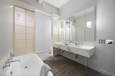 a bathroom with a tub sink and mirror