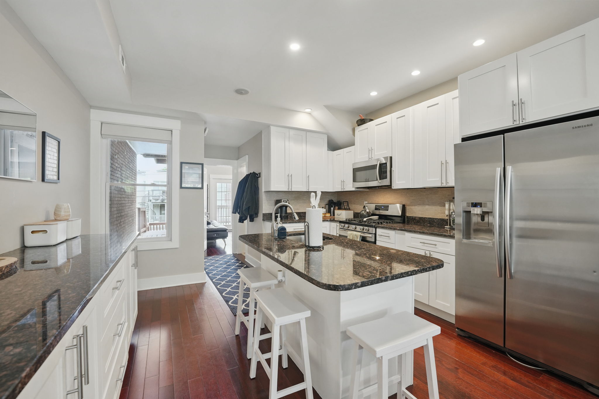 28 Q Street Northeast, Unit 2 Washington, DC 20002 - Photo 9 of 41 a kitchen with stainless steel appliances granite countertop a refrigerator a sink a stove a dining table and chairs