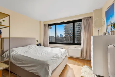 a bedroom with a bed and a large window with outer view