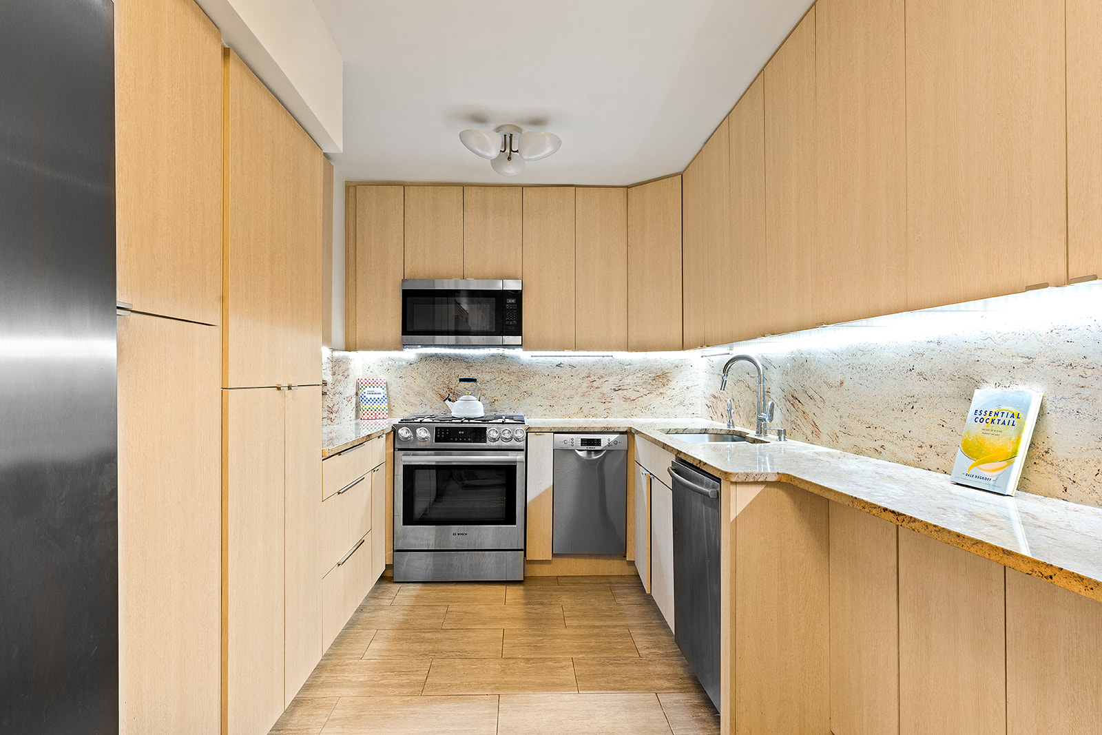 1160 3rd Avenue, Unit 4EF Manhattan, NY 10065 - Photo 2 of 11 a kitchen with stainless steel appliances granite countertop a stove a sink and a refrigerator