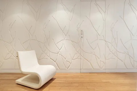 a spacious bedroom with a bed and a flat tv screen on wall