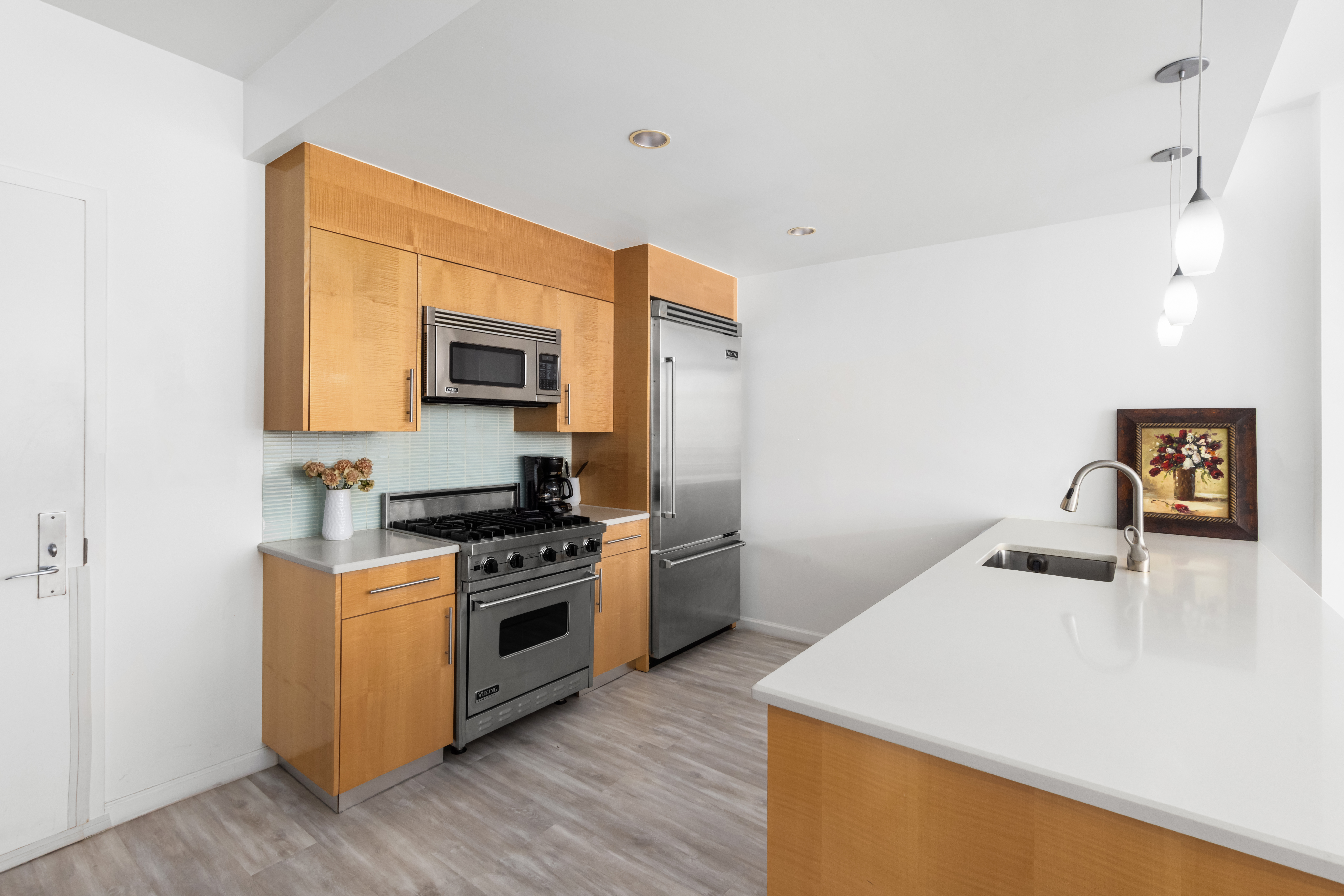 26 Broadway, Unit 402 Brooklyn, NY 11249 - Photo 3 of 17 a kitchen with a stove a sink and a microwave