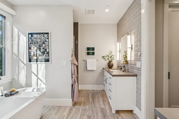 a bathroom with a granite countertop sink a mirror and shower