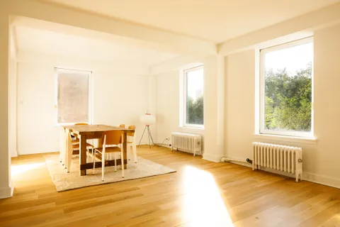 a dining room with wooden floor and window