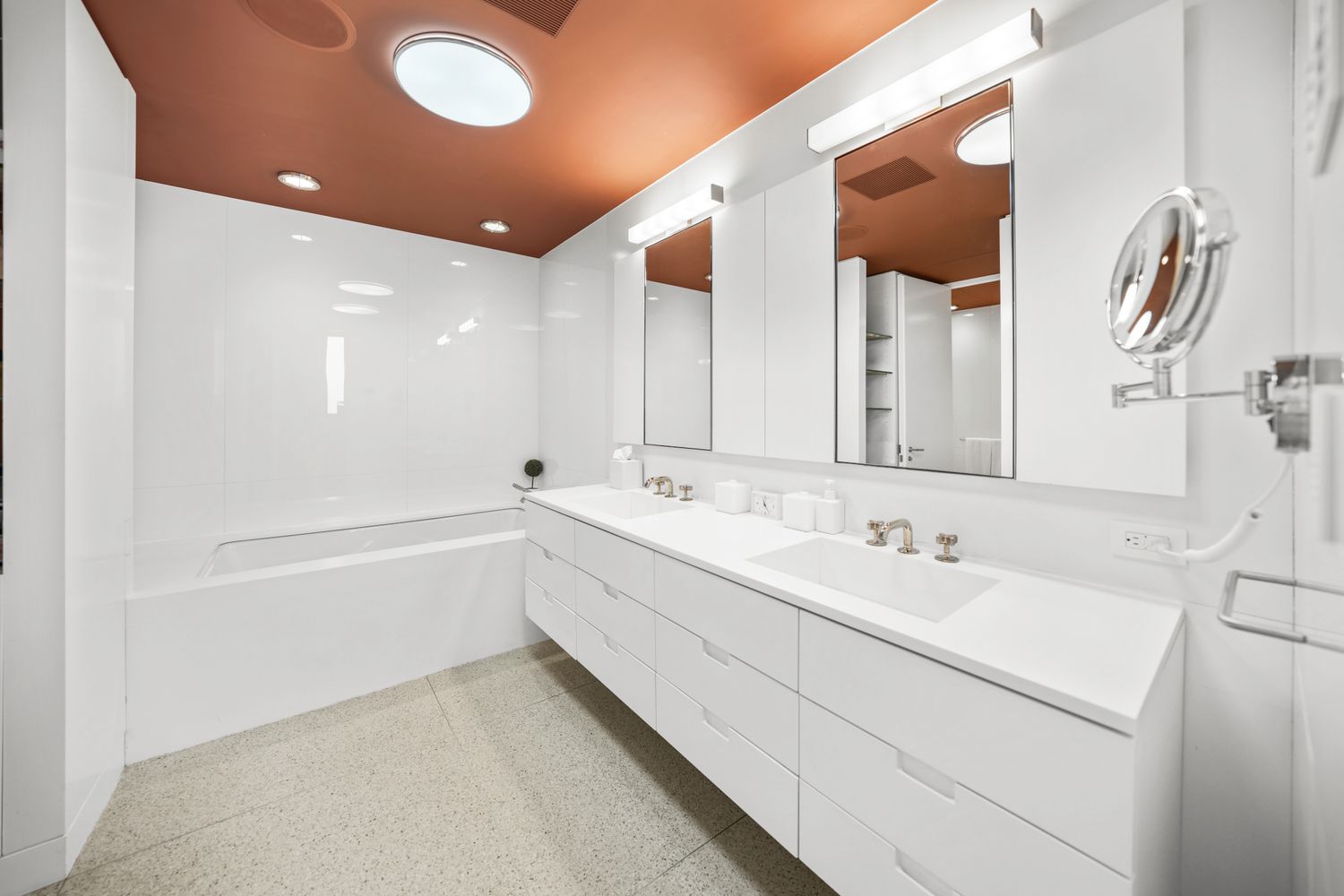 a bathroom with a double vanity sink and mirror with bathtub