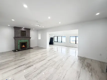 a view of empty room with wooden floor and fireplace