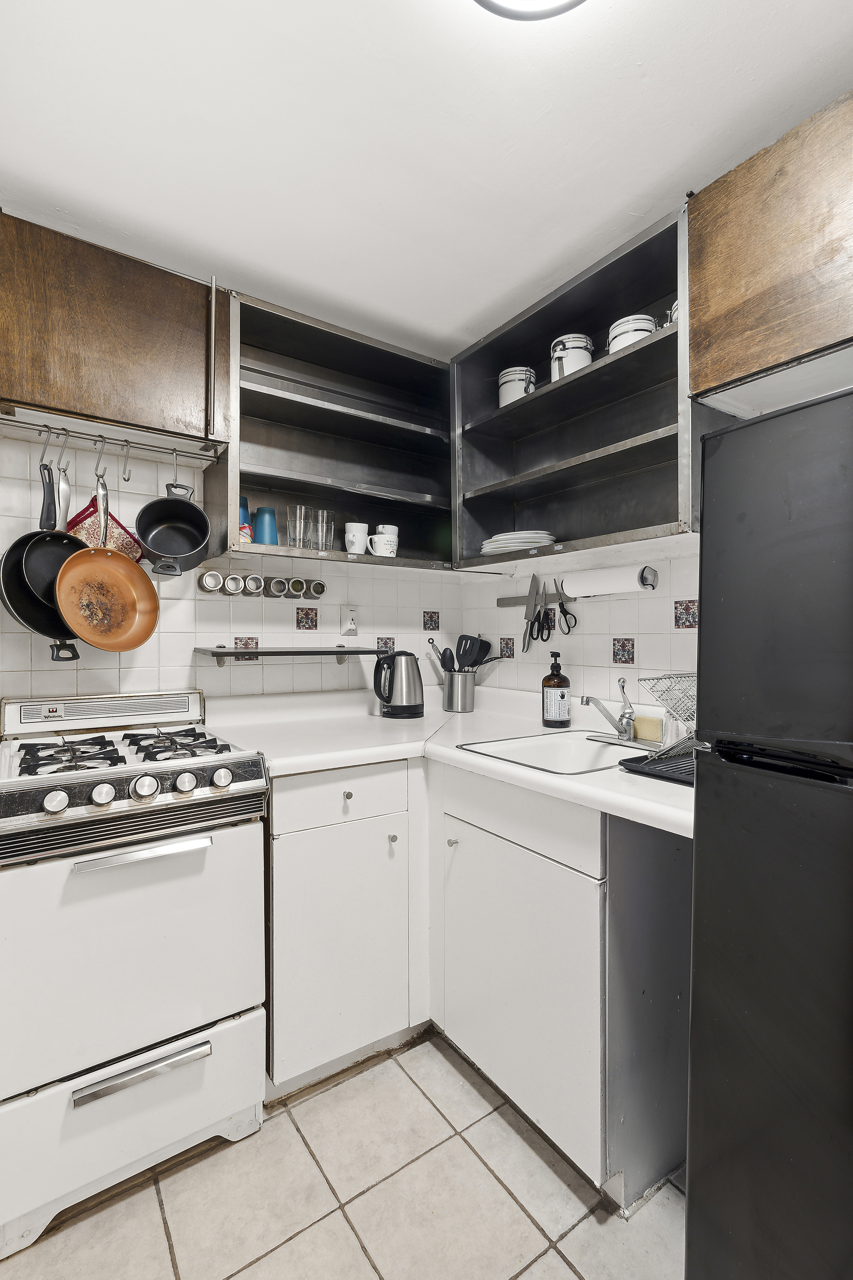 314 West 56th Street, Unit 4E Manhattan, NY 10019 - Photo 6 of 11 a kitchen with stainless steel appliances a stove and white cabinets