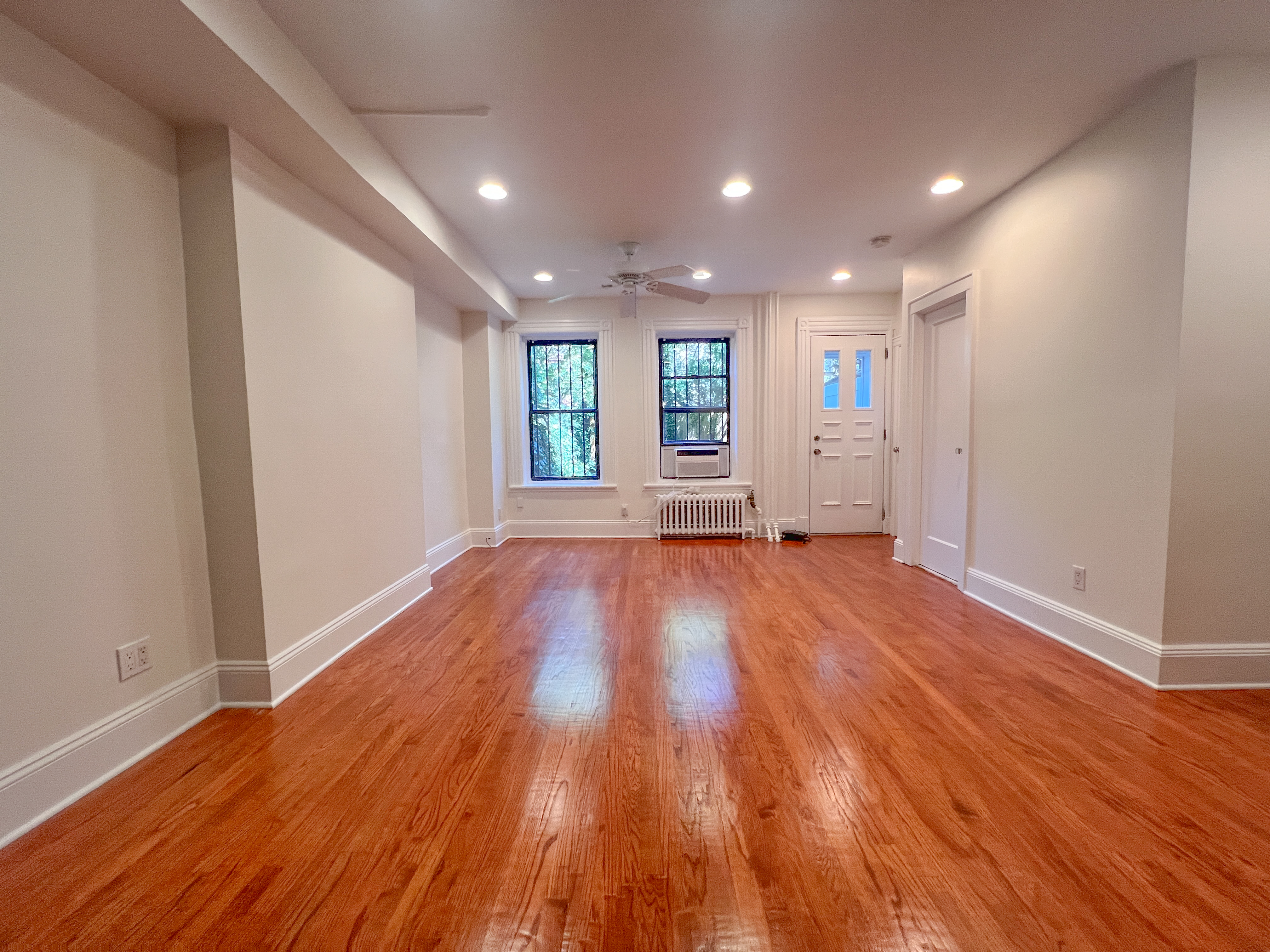 651 10th Street, Unit 1 Brooklyn, NY 11215 - Photo 3 of 15 wooden floor in an empty room with a window