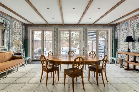 a dining room with furniture and large windows