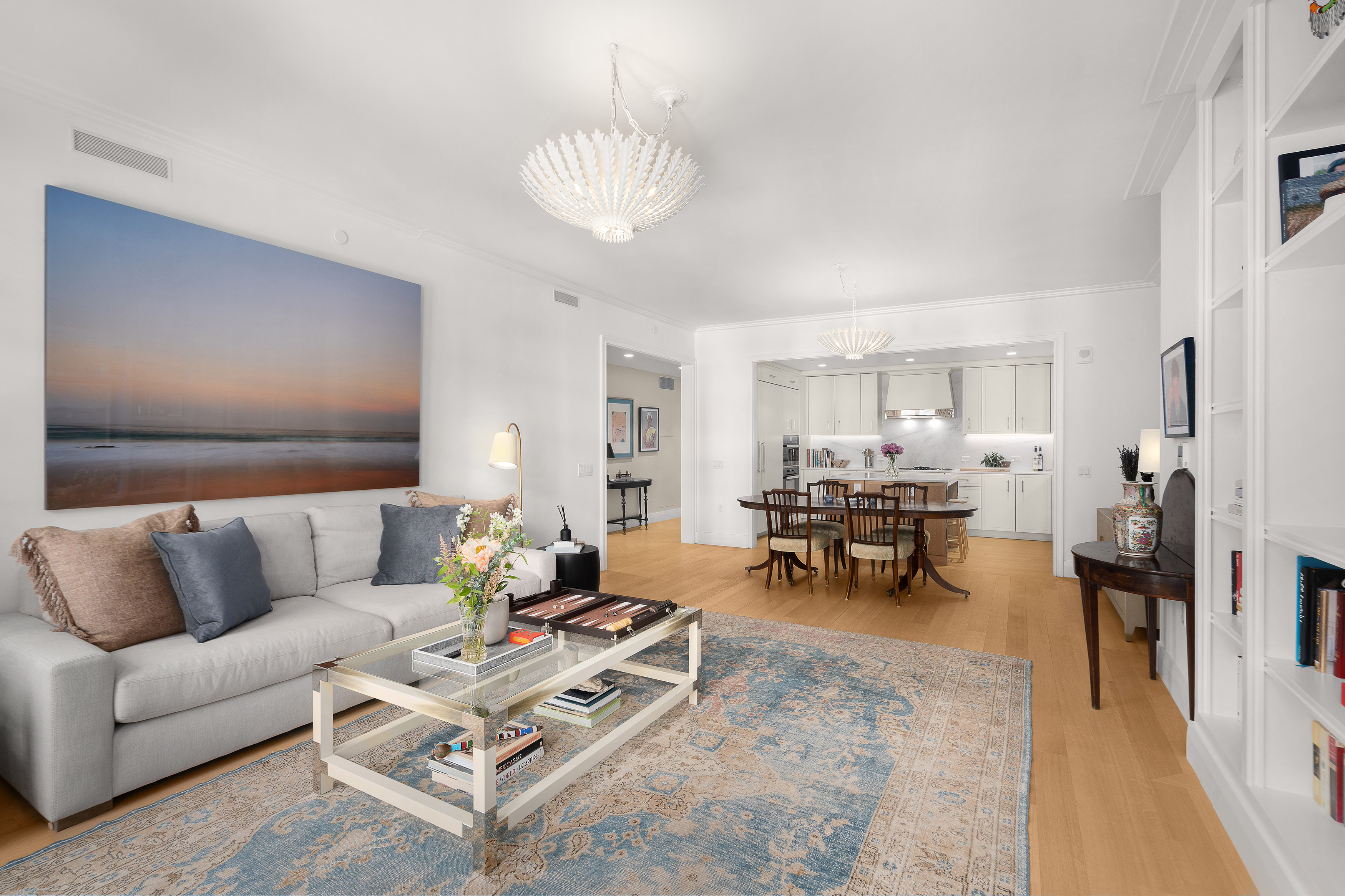 200 East 83rd Street, Unit 4E Manhattan, NY 10028 - Photo 4 of 29 a living room with furniture and a dining table with kitchen view