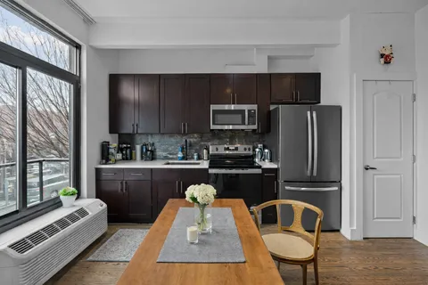 a kitchen with kitchen island granite countertop a refrigerator stove top oven and sink