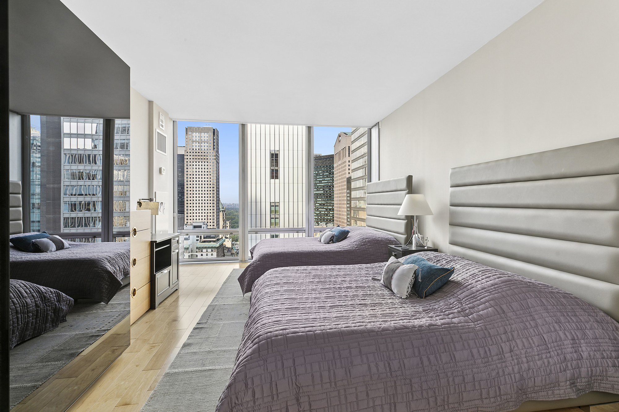 641 5th Avenue, Unit 28B Manhattan, NY 10022 - Photo 5 of 12 a large bedroom with a bed and glass windows